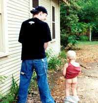 Man peeing outside with a baby copying him