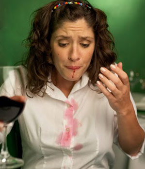 Woman spills red wine on her shirt