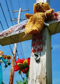 Teddy bear crucified on roadside memorial cross