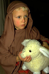 Religious child in a robe holding a lamb