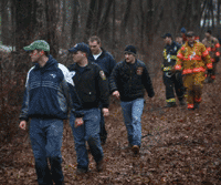 Men on a search party in the woods at dusk