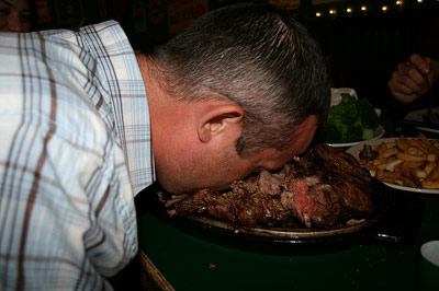 Guy face down in a steak plate at a restaurant