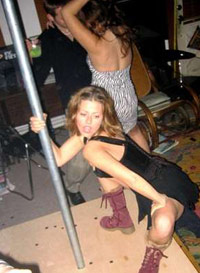 Woman loosely riding a stripper pole