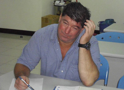 Teacher with his hand on his head at the desk