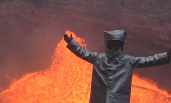 Man in a suit next to an active volcano