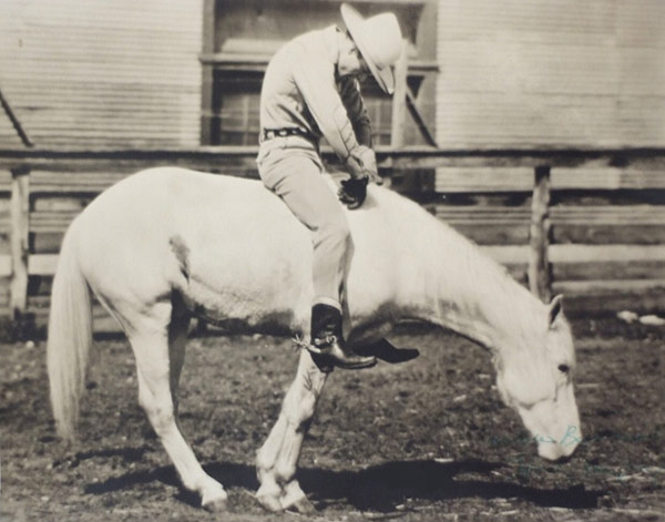 Sad cowboy hunched over on a horse