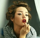 Hot girl putting on red lipstick