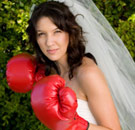Woman in wedding dress with boxing gloves on