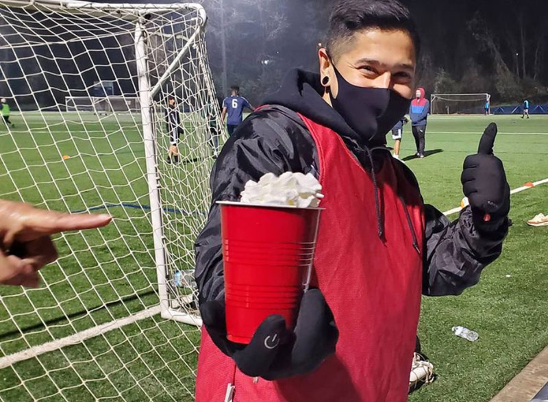 Fabricio drinking hot chocolate at the soccer field