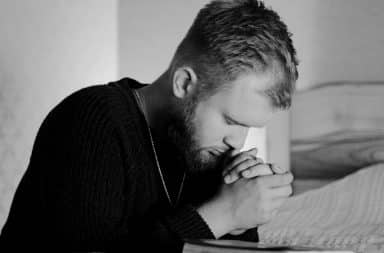 man in bed praying