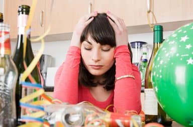 Woman holding her head with a hangover after drinking too much