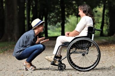 Two women outside, one in a wheelchair