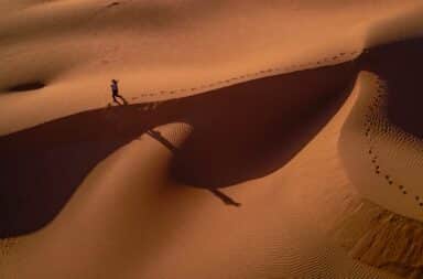 Man walking alone in Sahara Desert