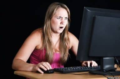 Woman shocked in front of a computer
