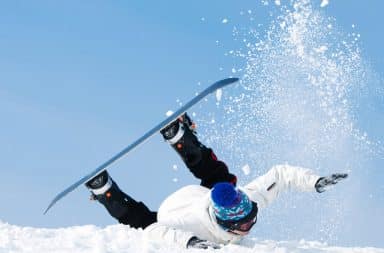 Snowboarder falls on slope