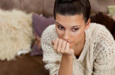 Contemplative single woman with hand on face