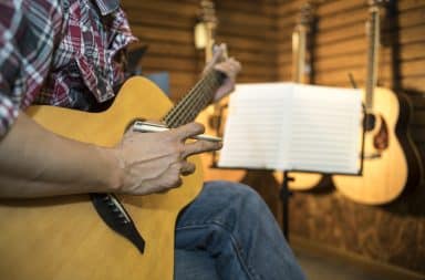 Man playing a guitar and writing a song