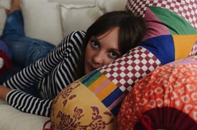 Woman lying on a pillow in a New York City apartment