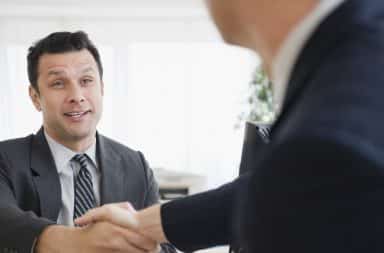 Businessmen shaking hands in office