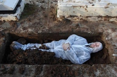 Dead Jewish man lying in an open grave at a cemetery