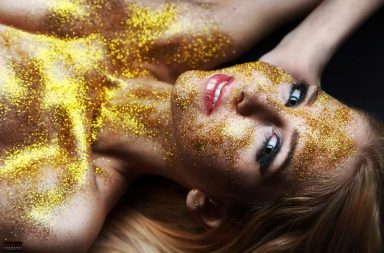 Sexy woman wearing only gold glitter