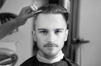 Black and white photo of a man with an undercut haircut and blue eyes