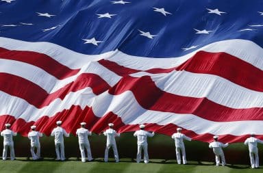 Marines holding a large American flag and waving it