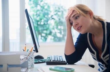 Woman looking at Facebook regretlfully