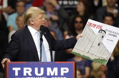 Donald Trump holds up a chart of the wall with Mexico