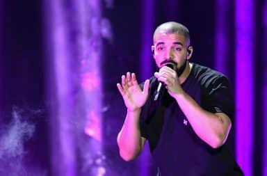 Drake bathed in purple light on stage on tour