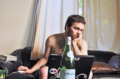 Man working from home naked on the couch