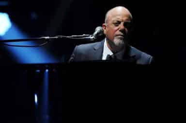 Billy Joel at a piano looking confused