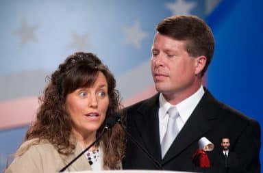 Michelle Duggar and Jim Bob speaking at a podium