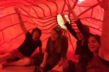 Women inside a red tent camping