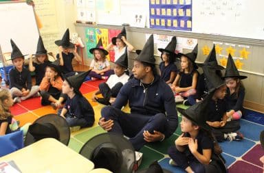 Kids sitting in a classroom wearing witch and wizard pointed hats