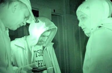 Ghost hunters using night vision while exploring paranormal activity