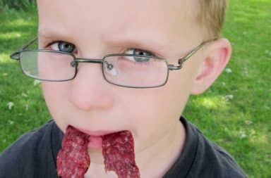 Boy with beef jerky in his mouth