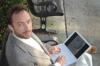 Jimmy Wales sitting down with laptop in his lap