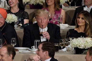 Trump drinking Diet Coke with a straw at a dinner table at a restaurant