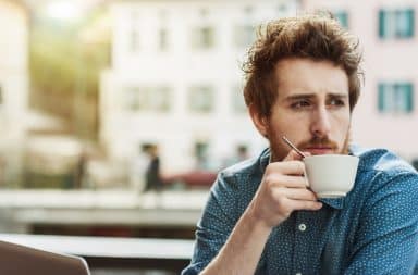 Man drinking coffee looking away