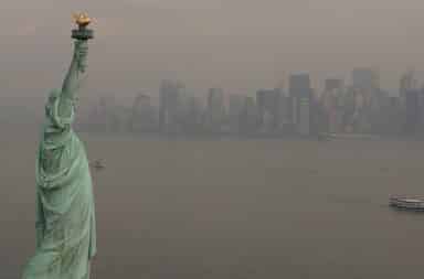 Statue of Liberty with New York City skyline and air pollution in the background