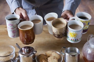 Man holding 7 cups of coffee