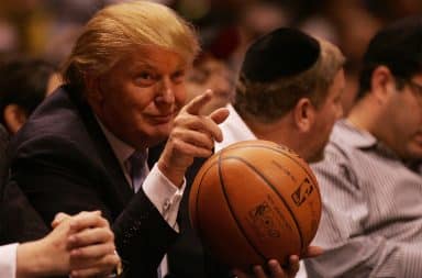 Donald Trump holding a basketball at an NBA game