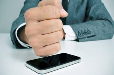 Man hitting smartphone with fist