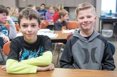 Fourth grade boys smiling in classroom