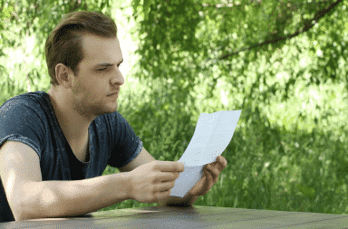 A man reads a letter, thoughtfully