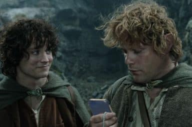 Sam checks his phone and Frodo looks on