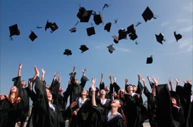 College students tossing graduation hats into the air