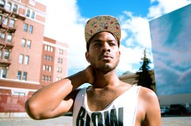 Black man with hat on thinking outside