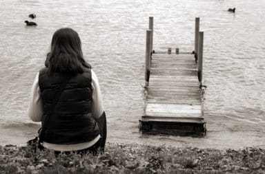 a sad woman alone on the shore